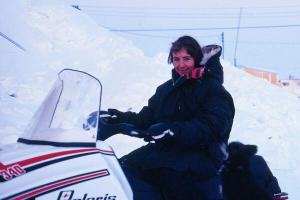 Nurse and Author Anne Watts riding a snowmobile in Canada